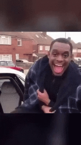Man Sticking Tongue Out Next to Car
