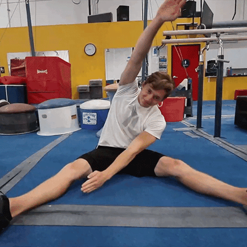 Man Stretching Legs In Gym With Ice Cold Water Cooler GIF