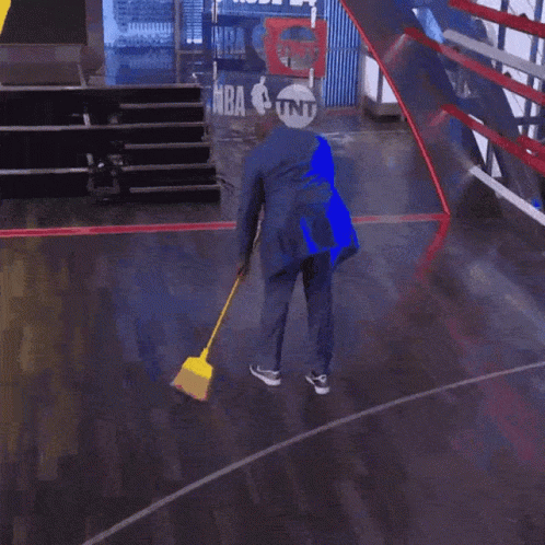 Man Sweeping Floor in Suit