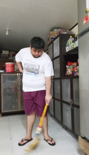 Man Sweeping Floor in White Scooter Shirt