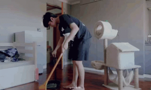 Man Sweeping Floor With Broom in Living Room