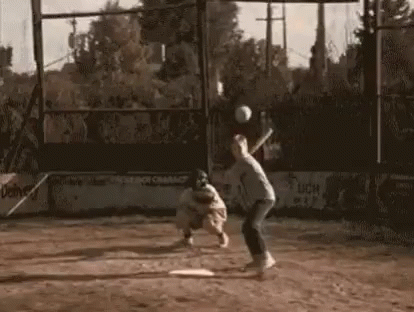 Man Swinging Bat at Baseball Catcher