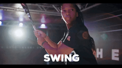 Man Swinging Bat in Front of Swing Sign