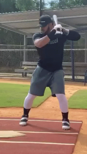 Man Swinging Bat on Baseball Field