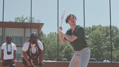 Man Swinging Bat While Catcher Watches