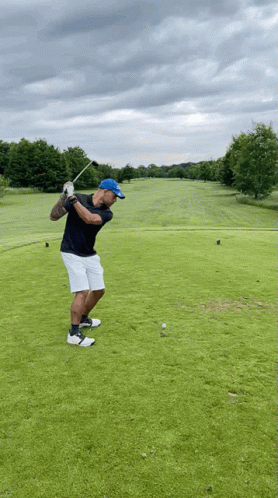 Man Swinging Golf Club at Ball