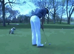 Man Swinging Golf Club at Golf Ball