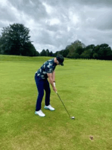 Man Swinging Golf Club at Golf Ball
