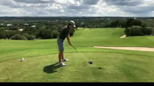 Man Swinging Golf Club at Golf Ball
