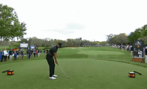Man Swinging Golf Club At Golf Ball GIF