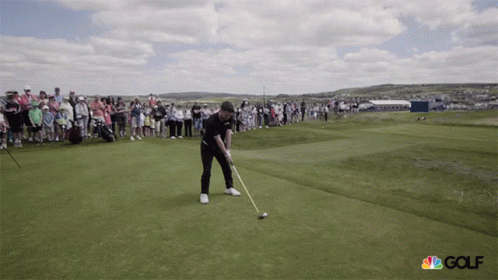 Man Swinging Golf Club on Course