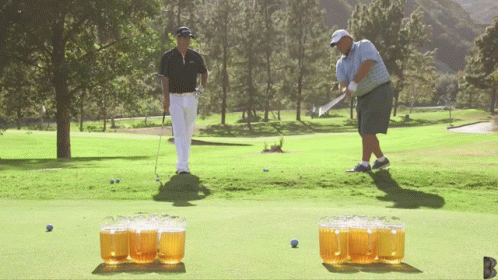 Man Swinging Golf Club While Another Watches