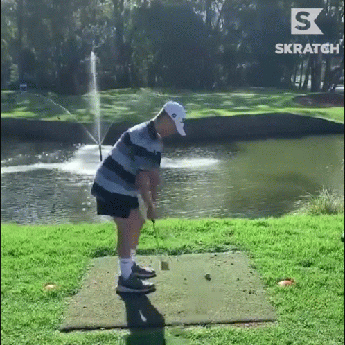 Man Swinging Golf Club With Fountain