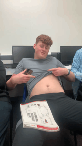 Man Taking Off Shirt Holding Book
