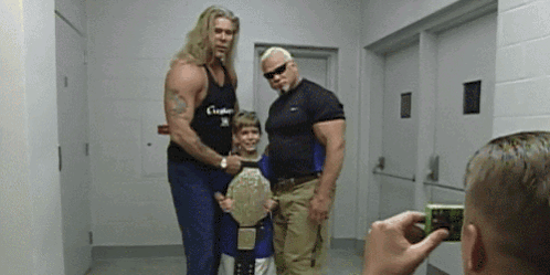 Man Taking Photo of Wrestlers and Boy with Belt