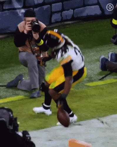 Man Taking Picture Of Football Player Holding Football GIF