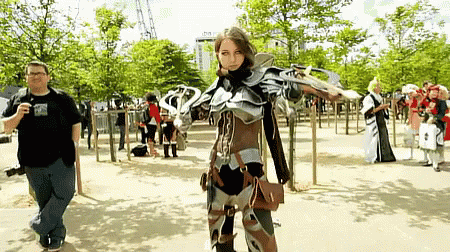 Man Taking Picture of Woman in Costume With Sword