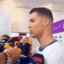 Man Talking into Microphone in White Shirt