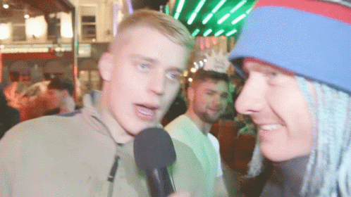 Man Talking Into Microphone With Blue And Red Hat GIF