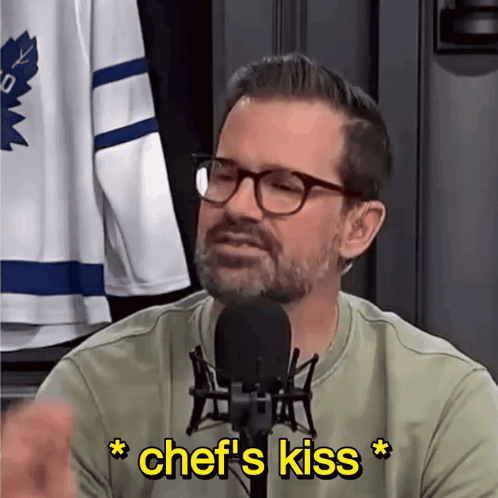 Man Talking Into Microphone With Yellow Chef's Kiss