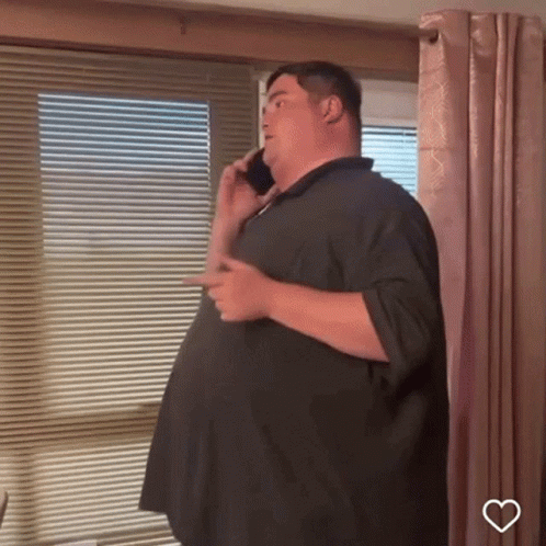 Man Talking on Cell Phone by Window