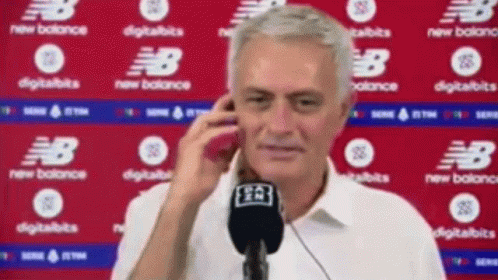 Man Talking on Cell Phone in Front of New Balance Sign