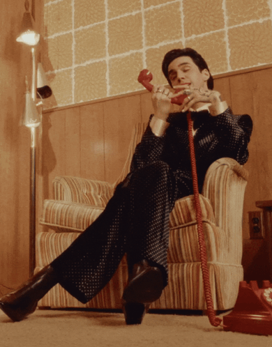 Man Talking on Red Phone