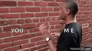Man Talking To Himself At Brick Wall GIF