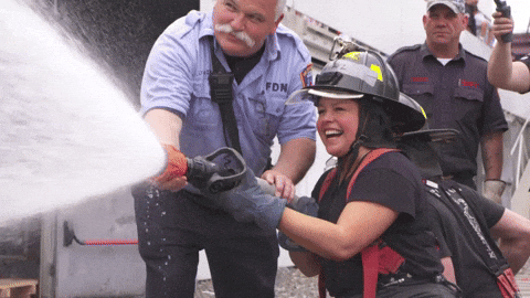 Man Teaching Woman To Hold Fire Hose GIF