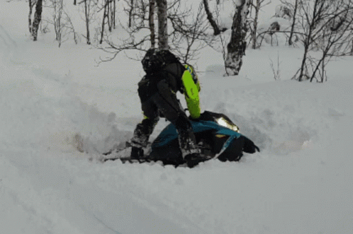 Man Trying To Upright A Snowmobile GIF