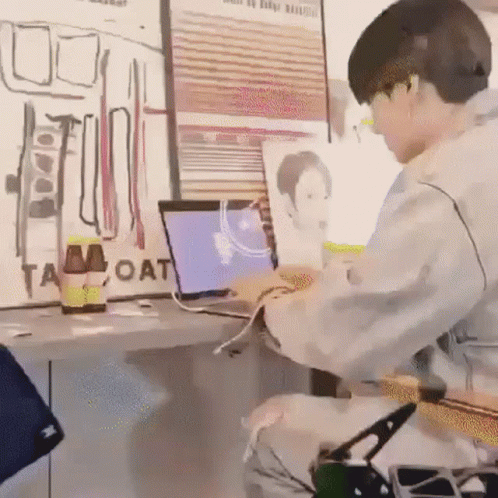 Man Using Laptop and Guitar at Desk