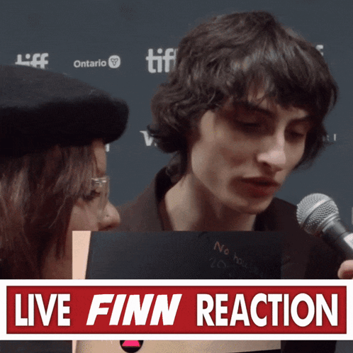 Man Using Microphone Beside Live Finn Reaction Sign