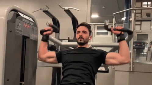Man Using Shoulder Press Machine