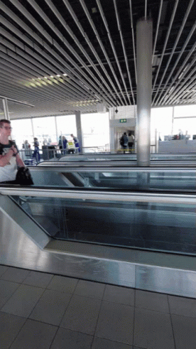 Man Walking Down Escalator With Exit Sign