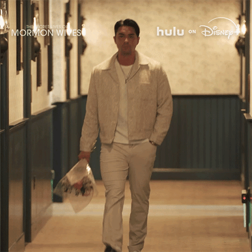 Man Walking Down Hallway With Flowers The Secret Lives of Mormon Wives