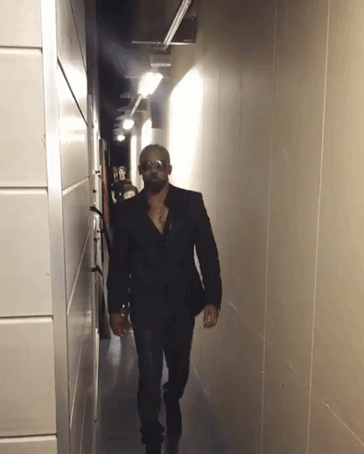 Man Walking Down Hallway with Sunglasses