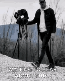 Man Walking Down Hill Holding Camera Waiting to Hear