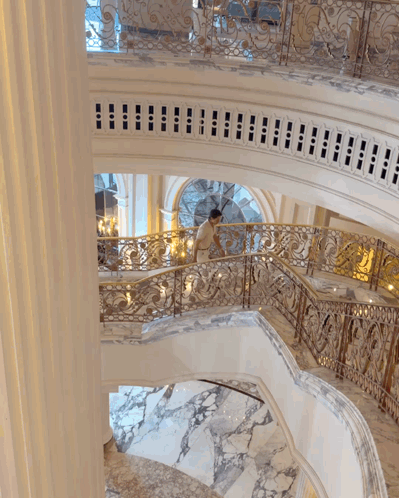 Man Walking Down Staircase With Fancy Railing