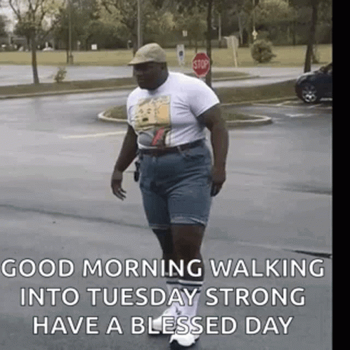 Man Walking Down Street In Hat And Shorts GIF