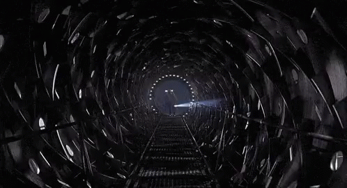 Man Walking Down Train Tracks In Dark Tunnel GIF