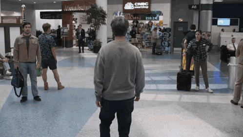 Man Walking in Airport With CNBC Smartshop on Wall