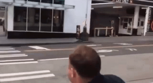 Man Walking In Front Of Exit Only Gas Station GIF