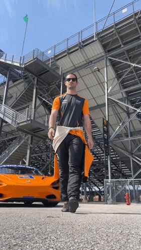 Man Walking In Front Of McLaren Race Car GIF