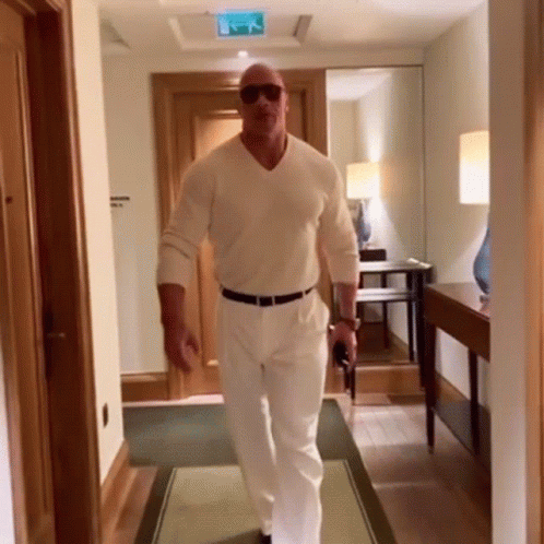 Man Walking in Sunglasses and White Shirt