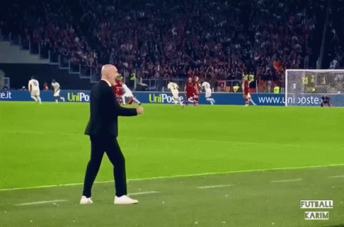 Man Walking on Soccer Field With Uniposte Ad