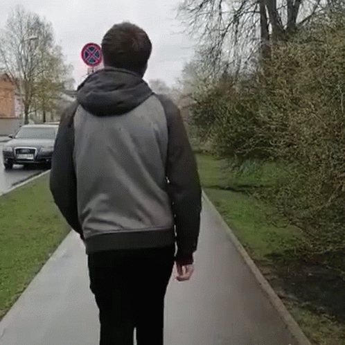 Man Walking Past No Parking Sign