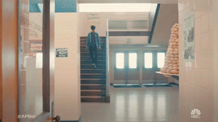 Man Walking Up Stairs in School Hallway