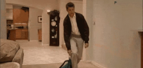 Man Walking With Suitcase and Backpack