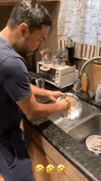 Man Washing Dishes in Kitchen Sink