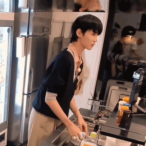 Man Washing Dishes in Kitchen With Coca Cola Bottle